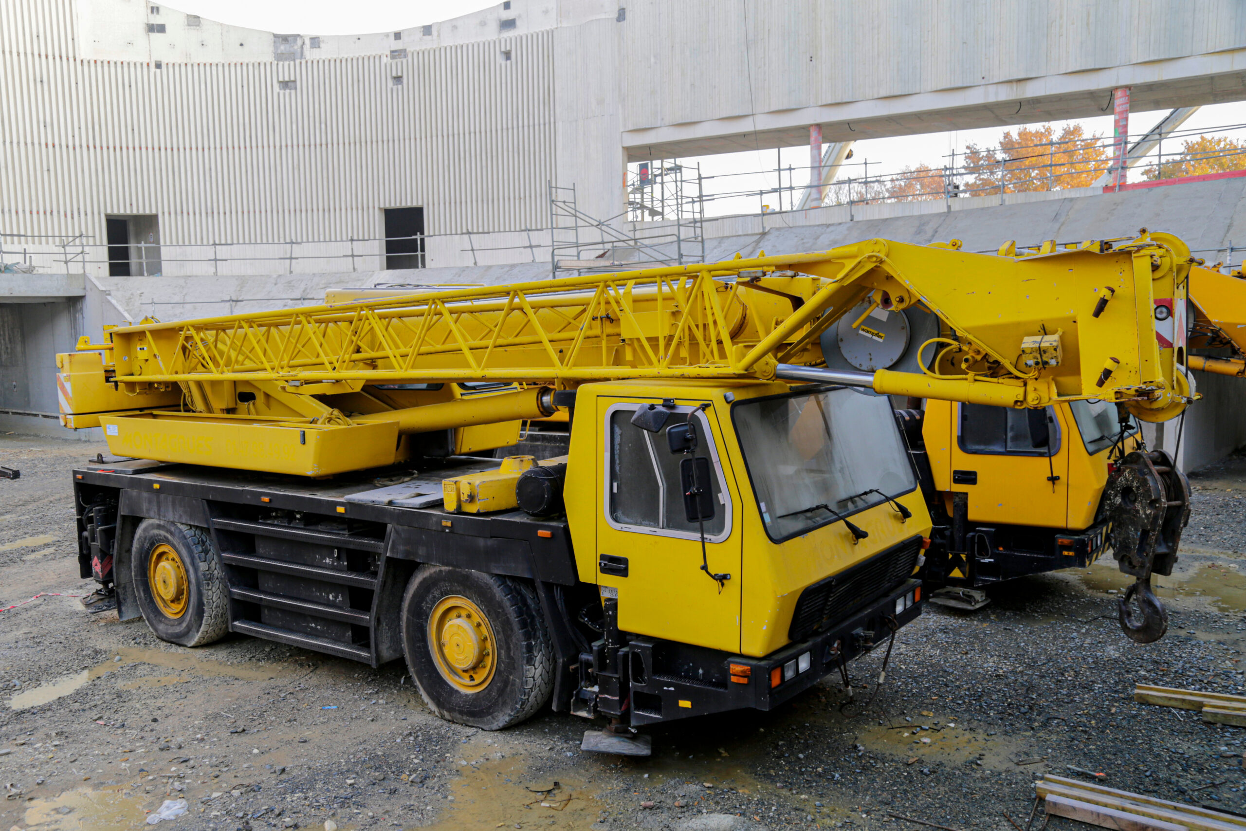 Vista dal basso di due operai su una piattaforma elevatrice con equipaggiamento di sicurezza in una giornata di sole